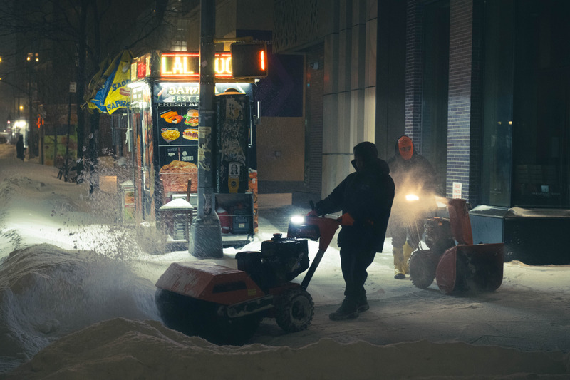 雪夜街道上的除雪车与行人