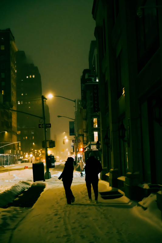 雪夜街道上并肩行走的人